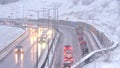 Cars driving on snowy road in winter, traffic on highway in snowfall, blizzard