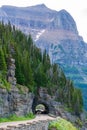 Cars driving through a tunnel carved from rock on a winding mountain road Royalty Free Stock Photo