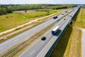 Cars and freight semi truck driving on busy highway across the country in beautiful summer evening. People on road trip traveling Royalty Free Stock Photo