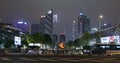 Cars go on the background of tall buildings at night. Guazhou, cars driving on the road, skyscrapers in the background