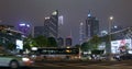 Cars go on the background of tall buildings at night. Guazhou, cars driving on the road, skyscrapers in the background