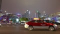 Cars go on the background of tall buildings at night. Guazhou, cars driving on the road, skyscrapers in the background