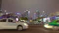 Cars go on the background of tall buildings at night. Guazhou, cars driving on the road, skyscrapers in the background