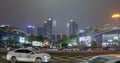 Cars go on the background of tall buildings at night. Guazhou, cars driving on the road, skyscrapers in the background