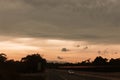 Cars Gracefully Moving Along the Road Under a Golden Overcast Sky Royalty Free Stock Photo