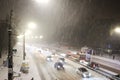 Cars on highway in blizzard. Winter in the city. Traffic jam and traffic camera at night. Cold snowy weather in town Royalty Free Stock Photo