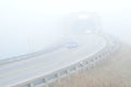 Cars on highway in fog with covered bridge Royalty Free Stock Photo