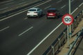 Cars on highway and SPEED LIMIT signpost in Madrid