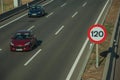 Cars on highway and SPEED LIMIT signpost in Madrid