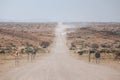 Cars kick up dust on the C35 gravel road in Tsiseb region, Namibia, Africa Royalty Free Stock Photo