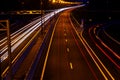 Cars light trails on a curved highway at night. Night traffic trails. Motion blur. Night city road with traffic headlight motion. Royalty Free Stock Photo