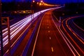 Cars light trails on a curved highway at night. Night traffic trails. Motion blur. Night city road with traffic headlight motion. Royalty Free Stock Photo