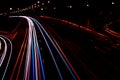 Cars light trails on a curved highway at night. Night traffic trails. Motion blur. Night city road with traffic headlight motion. Royalty Free Stock Photo