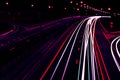 Cars light trails on a curved highway at night. Night traffic trails. Motion blur. Night city road with traffic headlight motion. Royalty Free Stock Photo