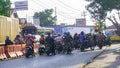 Cars, motorcycles, and pedicabs queue for the train to pass at the railroad crossing