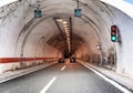 Cars move in a tunnel through a mountain on a freeway.