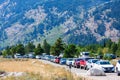 Cars of National Park visitors parked along the road during peak season near Jenny Lake.
