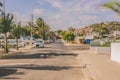 The cars parked along Unnamed Street with trees with a hill in the background in summer Royalty Free Stock Photo