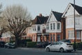 Cars parked in front of a row of Edwardian houses on a street in Palmers Green, London, UK