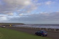 Cars parked on Kings Drive at Arbroath\'s Victoria Park shoreline with heavy seas Royalty Free Stock Photo