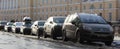 Cars parked in line on the roadside. Green grass in city street