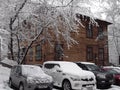 Cars in the Parking lot of an old wooden house in winter Royalty Free Stock Photo