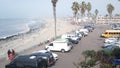 Cars and people on city street of Ocean Beach, San Diego, California. Palm trees
