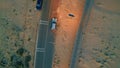 Cars riding desert road with headlights turning on at summer evening top view. Royalty Free Stock Photo