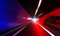 Cars rush through the tunnel in the beams of searchlights. Royalty Free Stock Photo