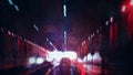 Cars speeding through a tunnel. Lit up by lights. With a blurred, grunge, neon edit