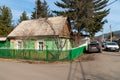 Cars stand near the house-museum of the writer V.P. Astafiev with a memorial plaque at the entrance on a sunny spring day