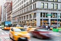 Cars, taxis and buses speed through the busy intersection of 23rd Street and 5th Avenue in New York City