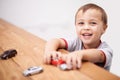 Cars, toys and boy kid by table playing for learning, development and fun at modern home. Cute, sweet and portrait of Royalty Free Stock Photo