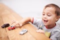 Cars, toys and boy kid by table playing for learning, development and fun at modern home. Cute, sweet and young child Royalty Free Stock Photo