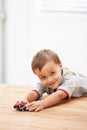 Cars, toys and portrait of child by table playing for learning, development and fun at modern home. Cute, sweet and boy Royalty Free Stock Photo