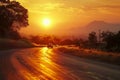 Cars traverse a country road under a mesmerizing golden sunset