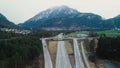 Cars Traverse the Road Amidst the Swiss Mountains through Motorways and Crossroads.