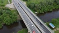 Cars and trucks drive along the road bridge across river