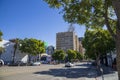 Cars and trucks driving along the street with lush green trees, office buildings, apartments and shops in Hollywood