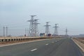 Cars and trucks driving on the highway in the background of transmission lines in Volgograd region