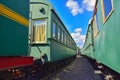 Between cars of vintage trains, between two old trains, old green wagons