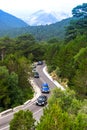 Cars on winding road to the Llogara Pass high in the green wooded mountains. Albania Royalty Free Stock Photo