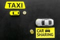 Carsharing vs taxi concept. Comparing carsharing system and taxi. Ship trip concept. Toy cars ans coins on black