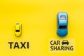 Carsharing vs taxi concept. Comparing carsharing system and taxi. Ship trip concept. Toy cars and text signs on yellow