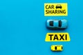 Carsharing vs taxi concept. Comparing carsharing system and taxi. Toy cars and text signs on blue background top view
