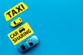 Carsharing vs taxi concept. Comparing carsharing system and taxi. Toy cars and text signs on blue background top view