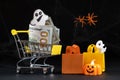 Cart with money hundred-dollar bills, paper bags for purchases. Halloween Sale Royalty Free Stock Photo