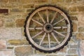 Cart wheel on an old stone wall Royalty Free Stock Photo