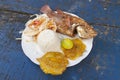 Cartagena de Indias, Colombia - Nov 21, 2010: A delicious plate of food, fried fish, rice, fried banana, lime and onion and tomato Royalty Free Stock Photo