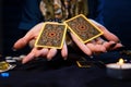 Cartomancy. The fortune teller holds out two Tarot cards on her palms. Close up. The concept of divination, astrology and Royalty Free Stock Photo